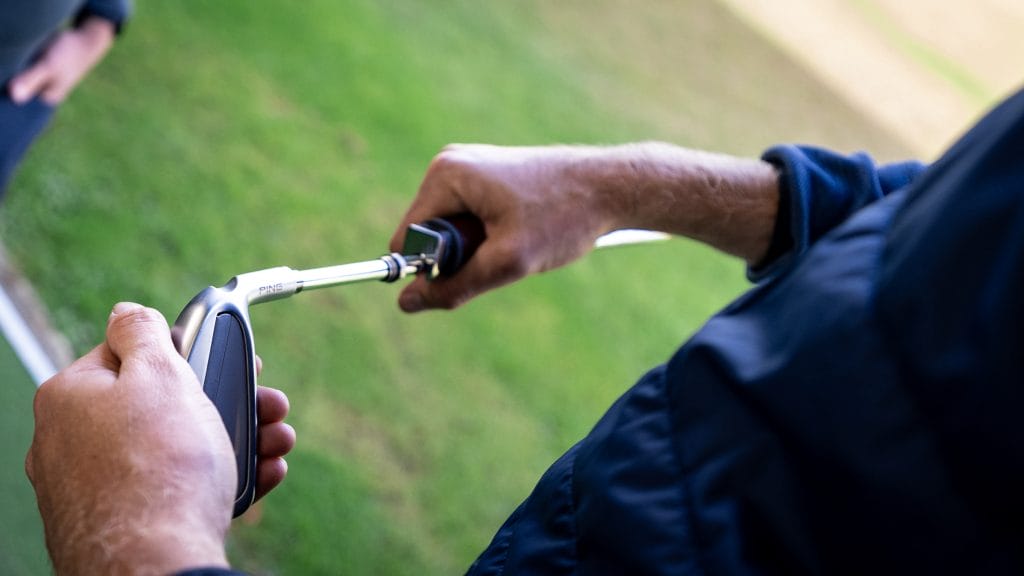 golf pro adjusting club length during a custom fitting session in nottingham