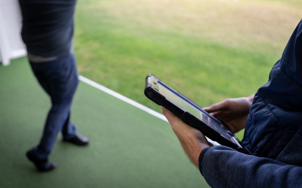 golf pro looking at statistics during a golf lesson in nottingham