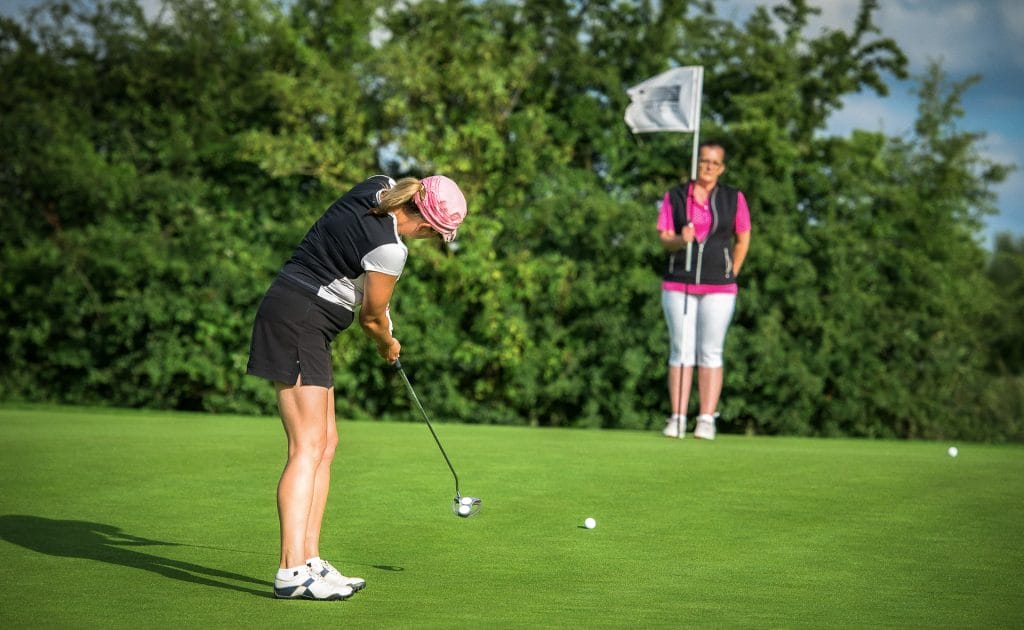 female Golfer hitting a long range putt at a golf course near calverton