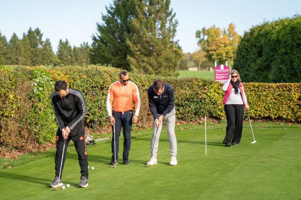 golfers practicing putting on a practice green in nottingham