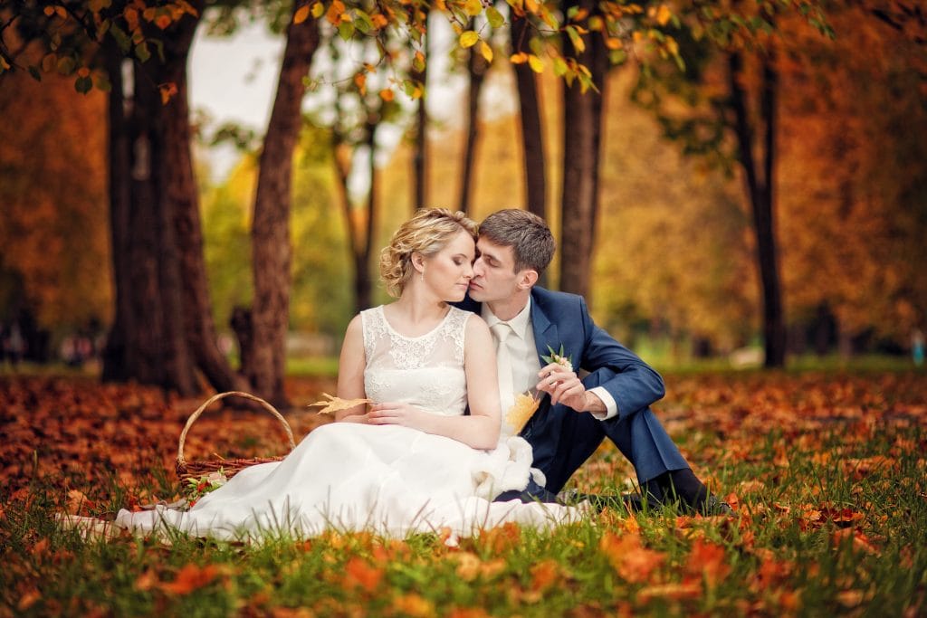 newly wed couple laying on the ground with orange leaves at a wedding venue in nottingham